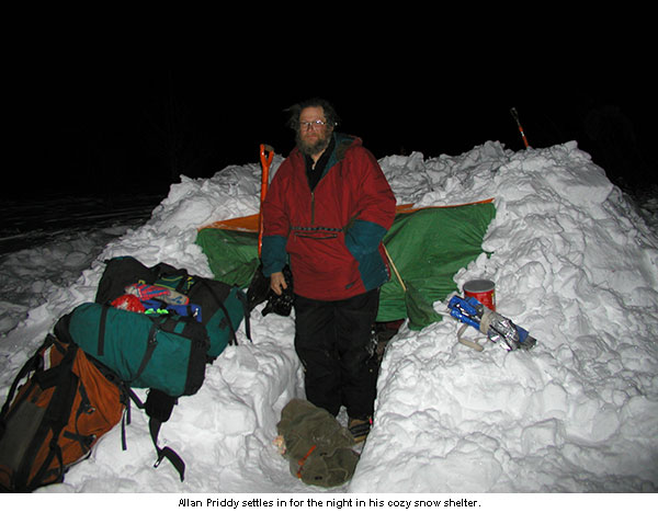 Allan Priddy settles in for the night in a snow trench shelter